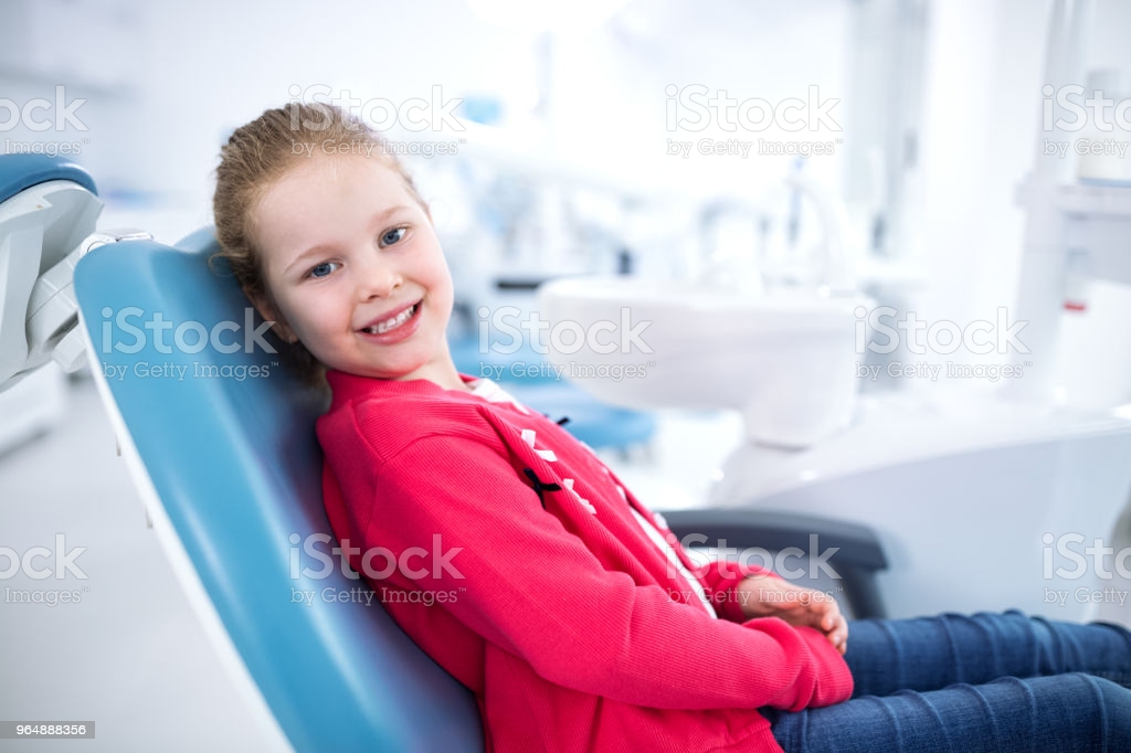 Beautiful smiling little girl in dental office, waiting for dental treatment